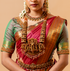 A woman wearing a traditional saree with gold-plated silver jewelry on a beige background