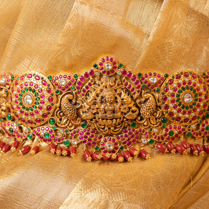 Decorative gold belt with gemstones on a gold fabric background